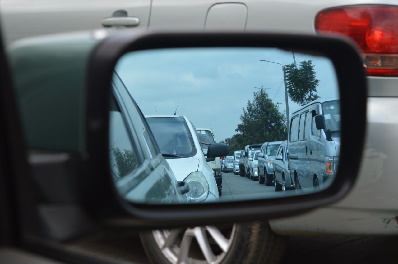 Car mirror showing lines of cars